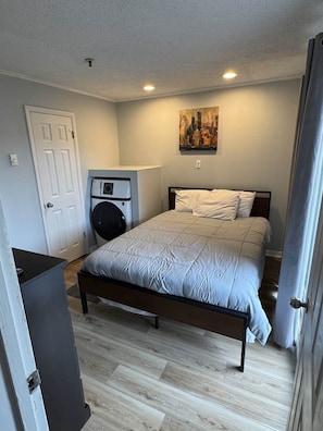 A bedroom with a bed, a wall-mounted heater, a door, and a painting. - Winterplace E103 Ski in Ski out condo First floor (Ghent)