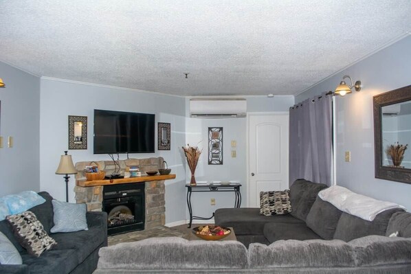 A living room with a fireplace, a television, and a sofa.