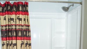 Ein Badezimmer mit Dusche, Toilette und einem Handtuchhalter.