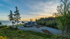 A large house with a driveway and a view of the water. - The Owl’s Nest | Panoramic Ocean View Retreat (Sooke)