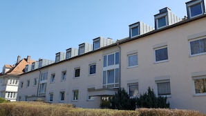 A multi-story residential building with multiple windows and a flat roof. - Studio Apartment Terrassengarten - Bad Kissingen (Bad Kissingen)