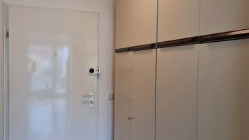 Ein Flur mit einer weißen Tür, Holzboden und einem Schrank mit mehreren Türen.