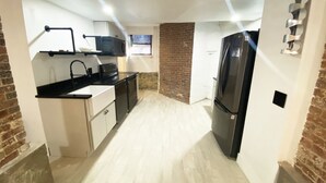 A compact kitchen with a black refrigerator, white cabinets, and a microwave. - Ultra cool new modern flat (Portland)