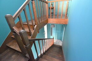 Stairs lead to an upper level with a table and chair.