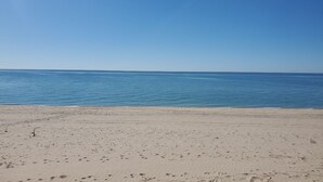 A beach with a clear sky and calm sea.