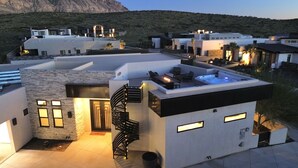 A modern building with a rooftop patio, a spiral staircase, and a hot tub.