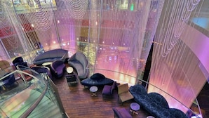 Un intérieur moderne avec une balustrade en verre, des espaces de détente et une vue sur le paysage urbain.