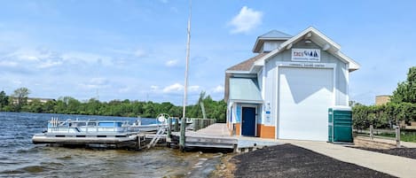 Un edificio blanco con un letrero que dice 'Cornwell Sailing Center' y un muelle con un bote.