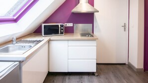 A modern kitchen with a skylight, a microwave, and a stove.