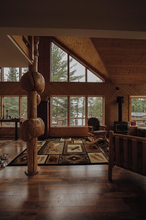 Un'ampia stanza con grandi finestre, soffitto in legno e camino.