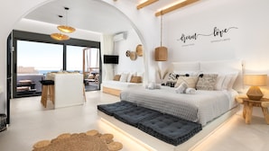 Une chambre moderne avec un grand lit, un bureau et une vue sur la mer.