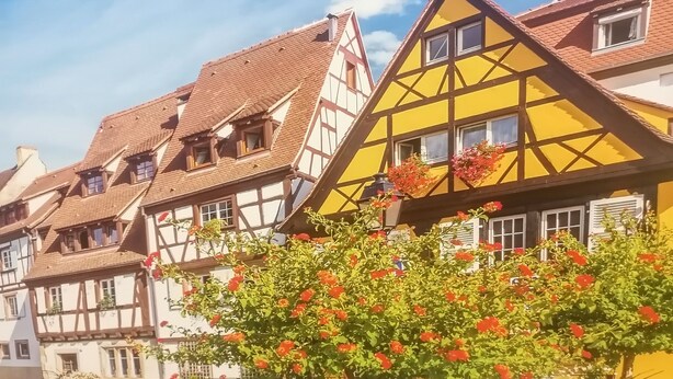 Een rij traditionele vakwerkhuizen onder een heldere lucht.