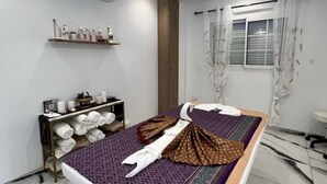 Une pièce bien rangée, avec un lit, une étagère contenant des articles de toilette et une fenêtre avec des rideaux.