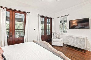 A bedroom with a large bed, two windows with curtains, a chair, a TV, and a radiator. - WATERCOLOR w PRIVATE POOL, LSV/GOLF CART INCLUDED! PARK DISTRICT, GORGEOUS!! (Santa Rosa Beach)