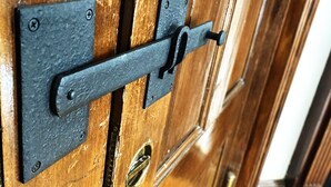 A wooden door with a metal latch and a keyhole.