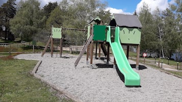 Un parque infantil con tobogán y estructuras para escalar.