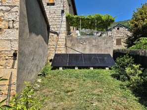 Un edificio de piedra con un panel solar en la fachada.