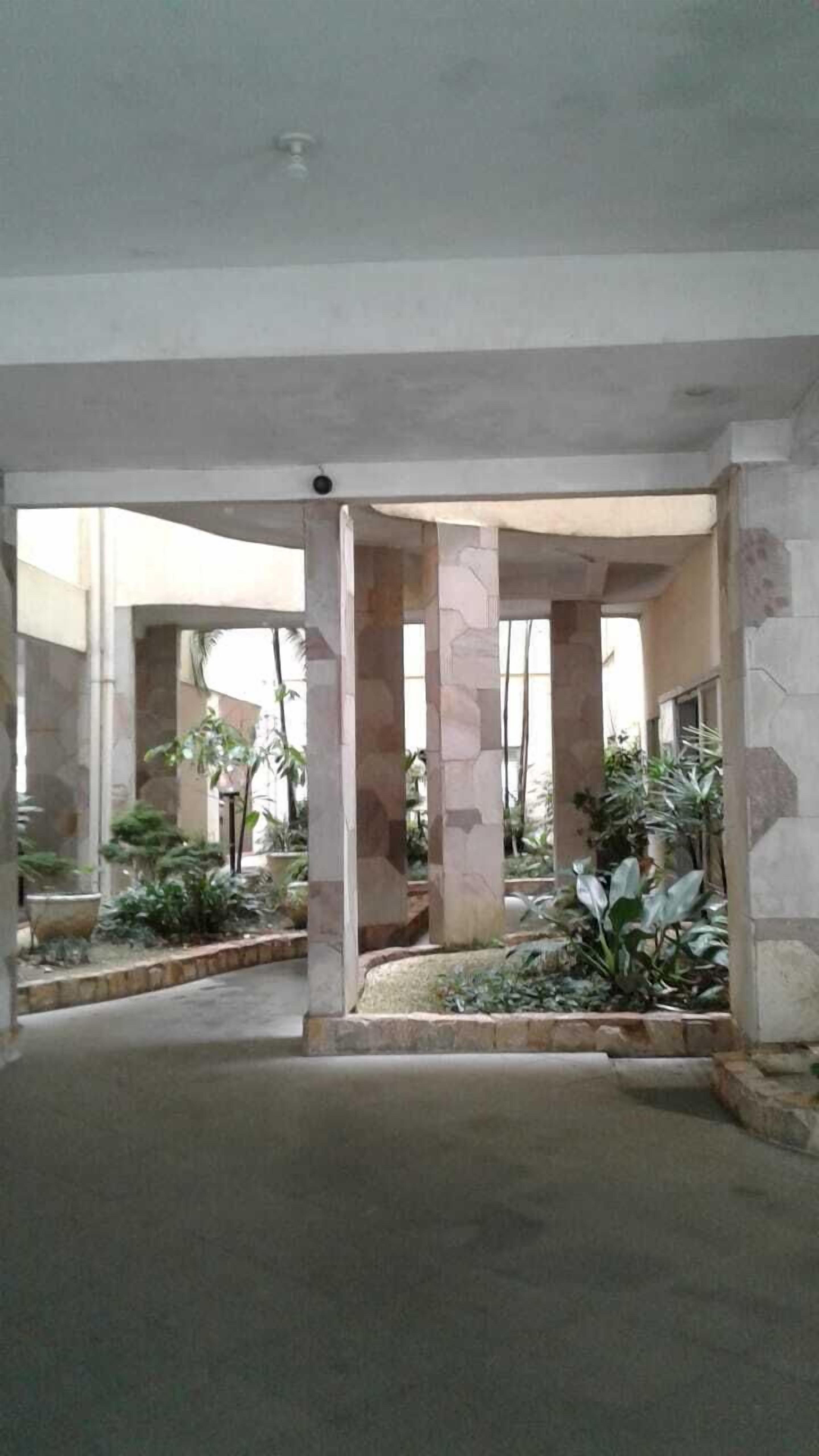 Een interieur met een centrale kolom, stenen muren en potplanten.