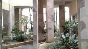 An interior space with a central column, stone walls, and potted plants. - Penthouse with its own barbecue near Enseada Beach - Guarujá (Guarujá)