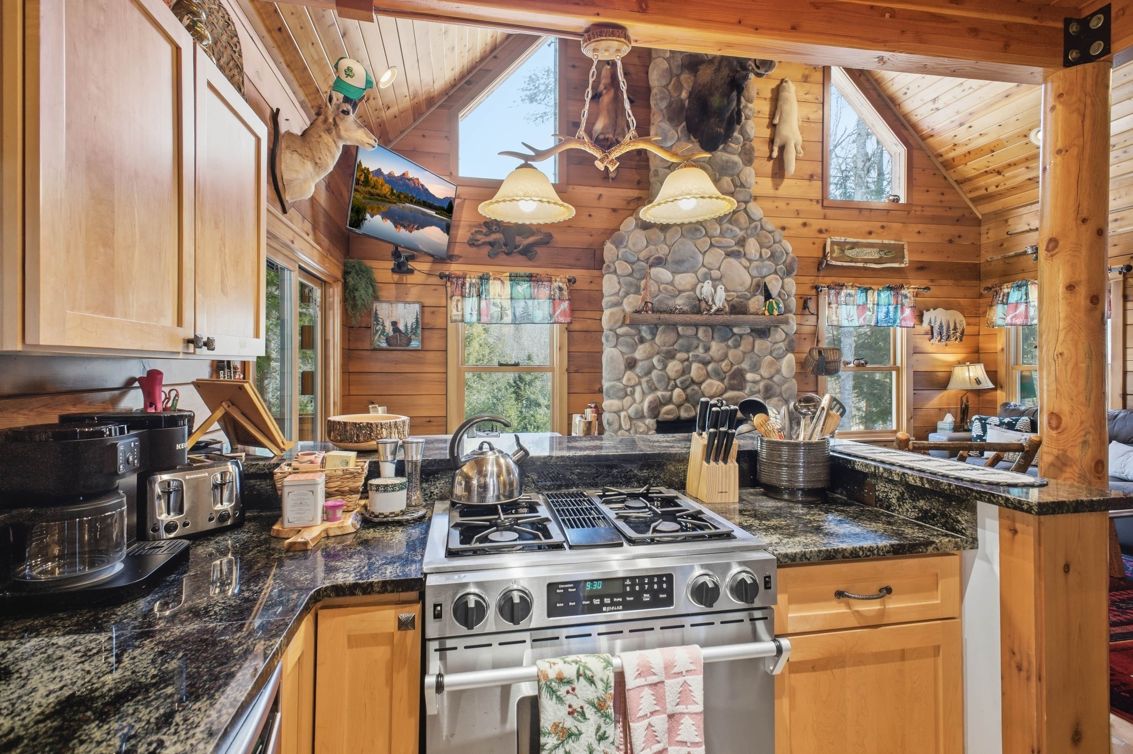 Une cuisine rustique avec des meubles en bois, une cheminée en pierre et une cuisinière à gaz.