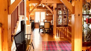 A wooden interior with a dining area, a staircase, and a stained glass window. - Luxury Log Home, Southern Georgian Bay - Explore Blue Mountain to Tobermory (Annan)