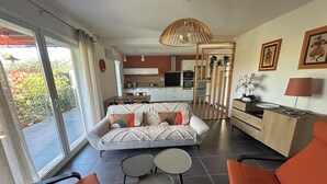 A modern living room with a sofa, two chairs, a dining table, a kitchen area, and a balcony with a view. - Villa Coquelicot - Private swimming pool - Electricity terminal (Moussac)