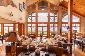 A spacious room with large windows, wooden furniture, and a view of the outdoors. - Headwaters Hideaway 2 bed 2 and a half bath  home in gated community near Banner Elk (Banner Elk)