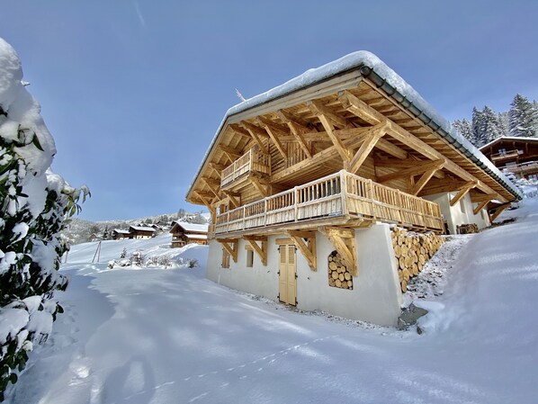 Una cabaña de madera con balcón, rodeada de un paisaje nevado.