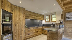 Une cuisine moderne avec des meubles en bois, des appareils en acier inoxydable et un grand îlot central.