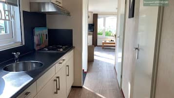 Een koelkast, een oven, een kookplaat, een koffiezetapparaat/waterkoker