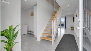 A modern interior with a staircase, a kitchen area, and a living space. - Lovely home in Thisted (Thisted)