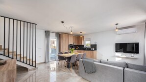 En moderne lejlighed med spiseområde, køkken, opholdsstue og trappe.