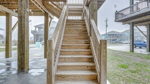 Un escalier en bois offrant une vue sur les environs, notamment sur un bâtiment et une rue.