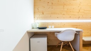 A compact kitchenette with a white countertop, a small refrigerator, and a white chair. - Apartments Kamr'ca - room 2 & 5 with private bathroom (Ljubljana)