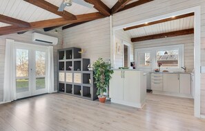 A spacious kitchen with wooden beams, a large window, and a potted plant. - Gorgeous home in Bjert with WiFi (Bjert)