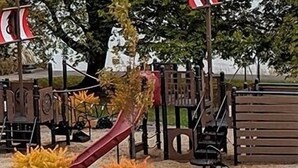Un'area giochi con uno scivolo, strutture per arrampicarsi e una panchina.