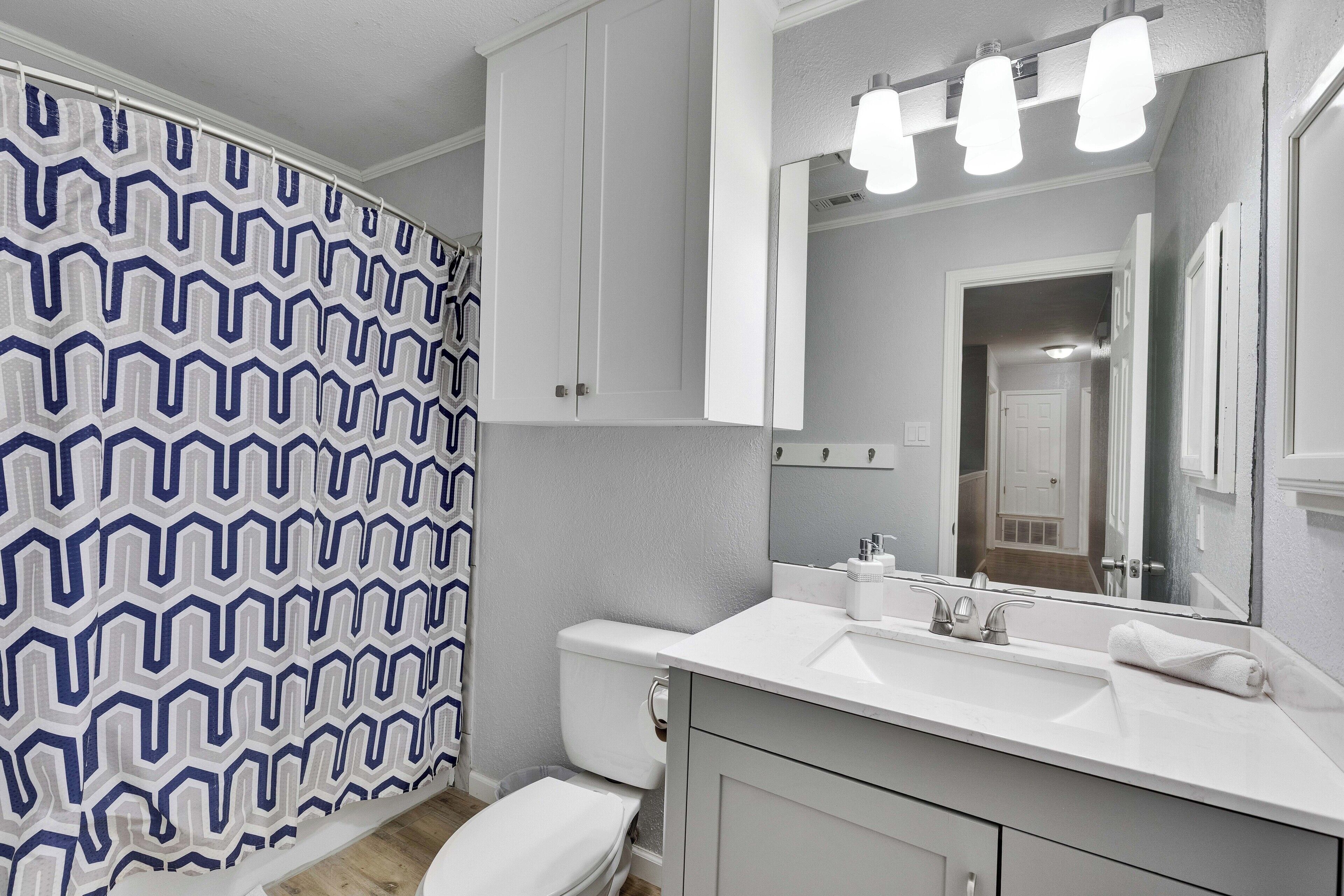 Une salle de bain avec un lavabo blanc, un miroir et des toilettes.