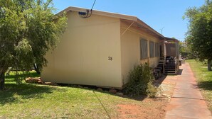 A single-story mobile home with a number 28 on the side, a covered porch with outdoor furniture, and a paved driveway. - Exmouth Villas Unit 28 - This Villa is Perfect for groups and families alike (EXMOUTH)