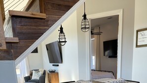 A kitchen with white cabinets, a granite countertop, and a wooden accent wall.