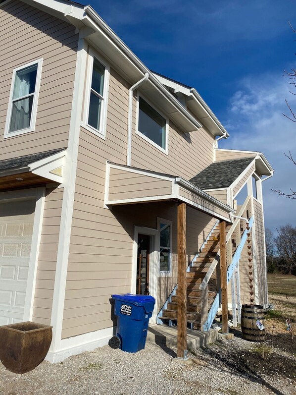 A two-story house with a covered porch and a front staircase. - Memphis Meadows - Collierville Home - privacy with great views (Collierville)