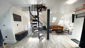 A spacious loft with a central staircase, a cozy seating area, and a large window providing natural light. - Victorian architecture dipped in refined modernity. May-June-July special!!! (Portland)