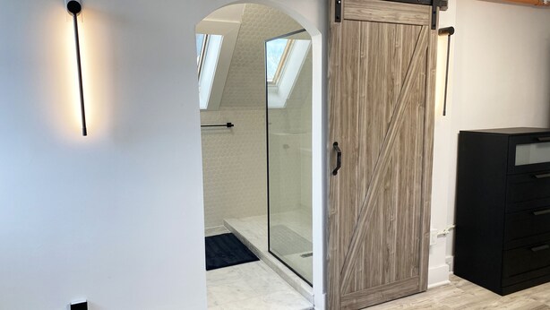 A modern interior with a sliding barn door, a glass shower enclosure, and a black filing cabinet. - Victorian architecture dipped in refined modernity. May-June-July special!!! (Portland)