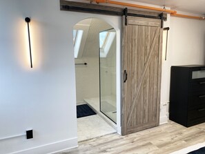 A modern interior with a sliding barn door, a glass shower enclosure, and a black filing cabinet. - Victorian architecture dipped in refined modernity. May-June-July special!!! (Portland)
