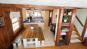 Un intérieur en bois comprenant un coin cuisine, une table à manger et un escalier.