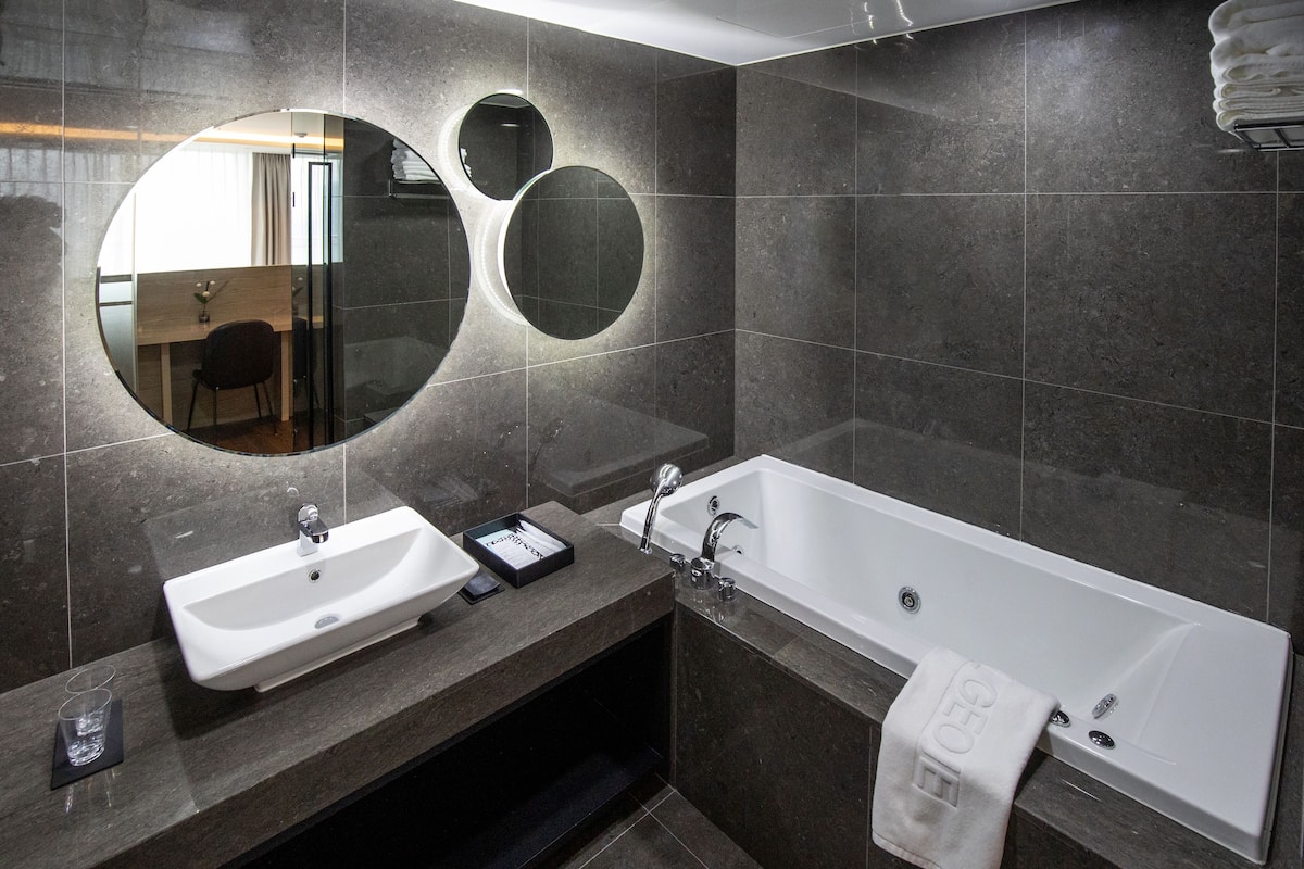 loft executive suite | bathroom | deep-soaking bathtub, hair dryer, slippers, bidet