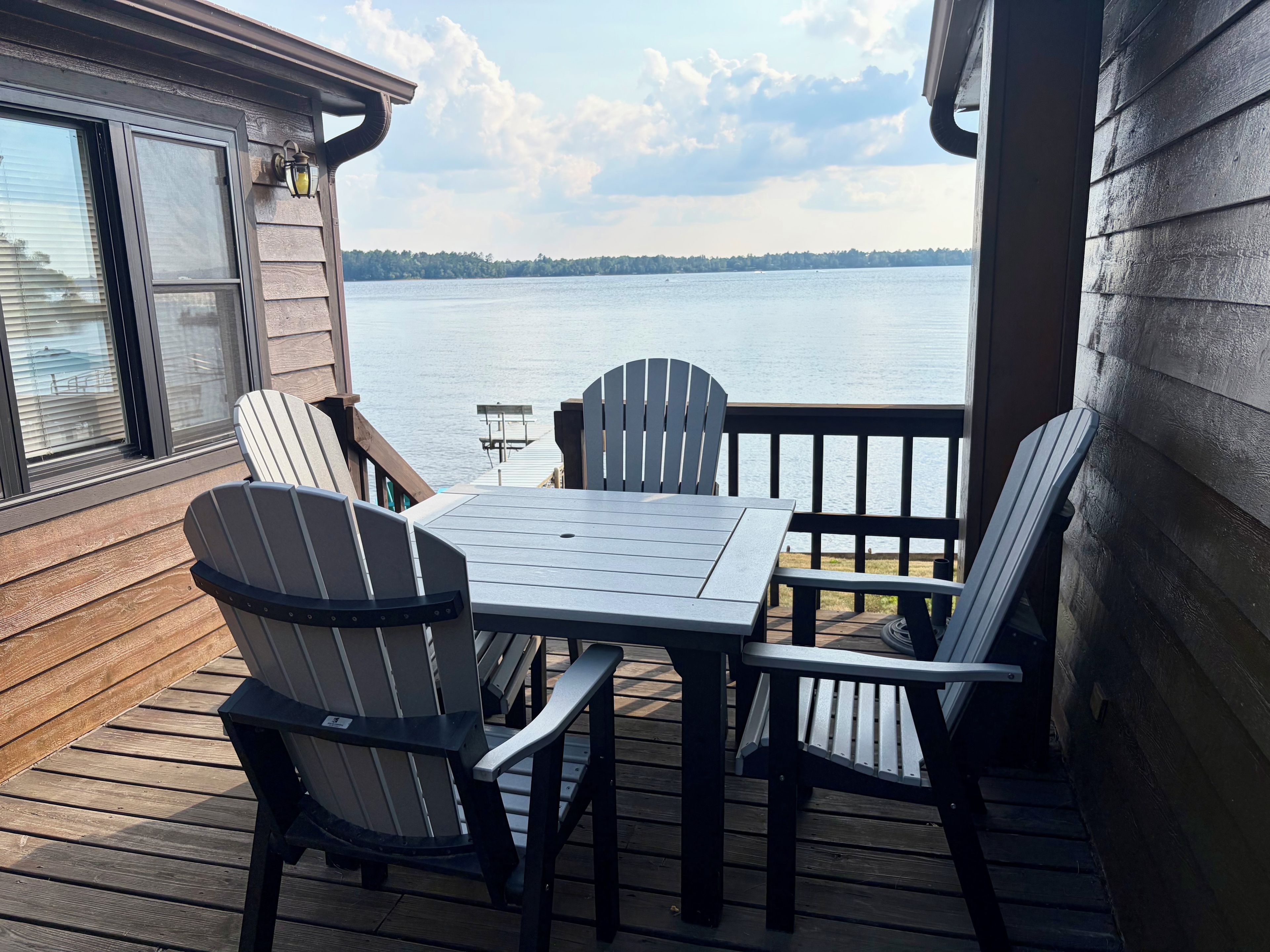 Une terrasse avec une table et des chaises donnant sur un lac.