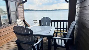 Une terrasse avec une table et des chaises donnant sur un lac.