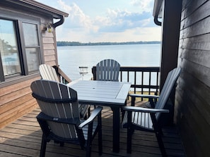 Terraza con mesa y sillas con vista a un lago.