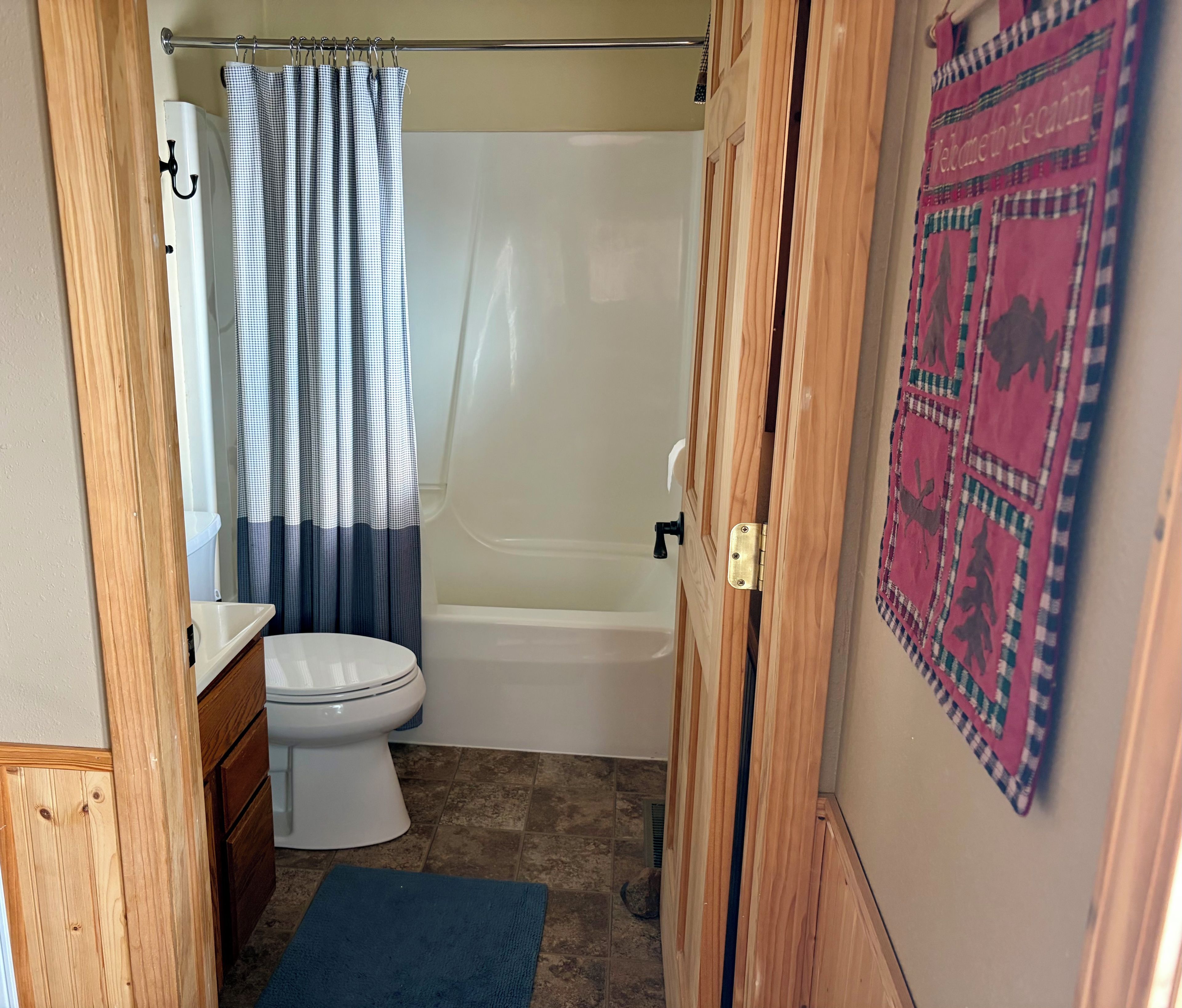 A bathroom with a toilet, a bathtub, and a shower curtain.