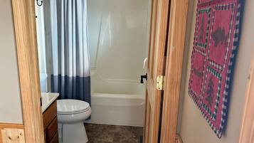 A bathroom with a toilet, a bathtub, and a shower curtain.